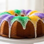Bundt pan cinnamon roll king cake with Mardi Gras icing