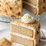 Full Italian cream cake on stand with coconut and frosting