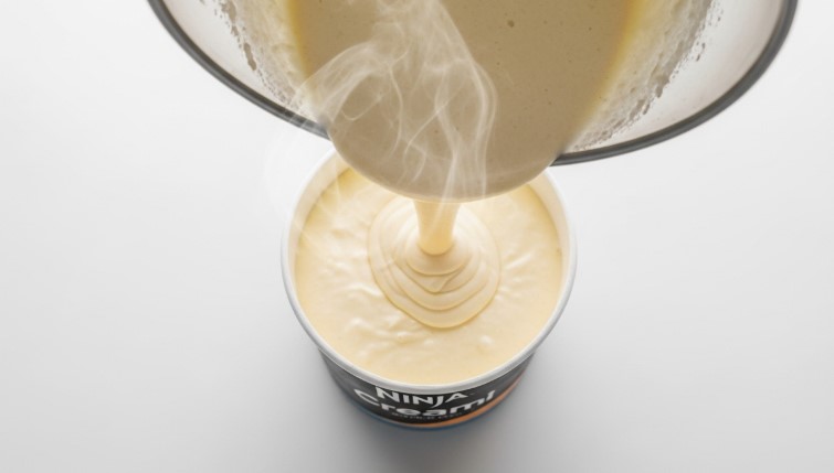 Pouring vanilla base into the Ninja Creami pint container